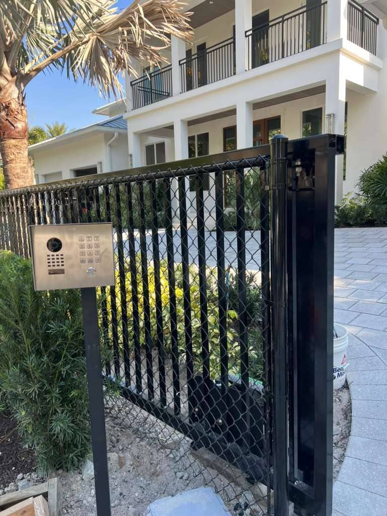 Finished intercom and callbox post beside a gated driveway entrance