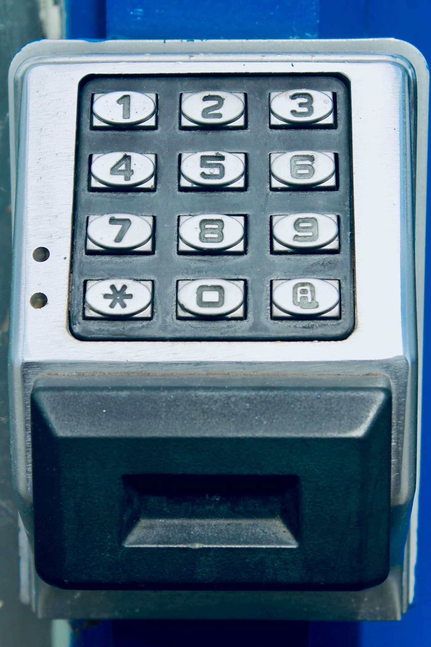 Keypad with an integrated card reader mounted on a blue entry pedestal