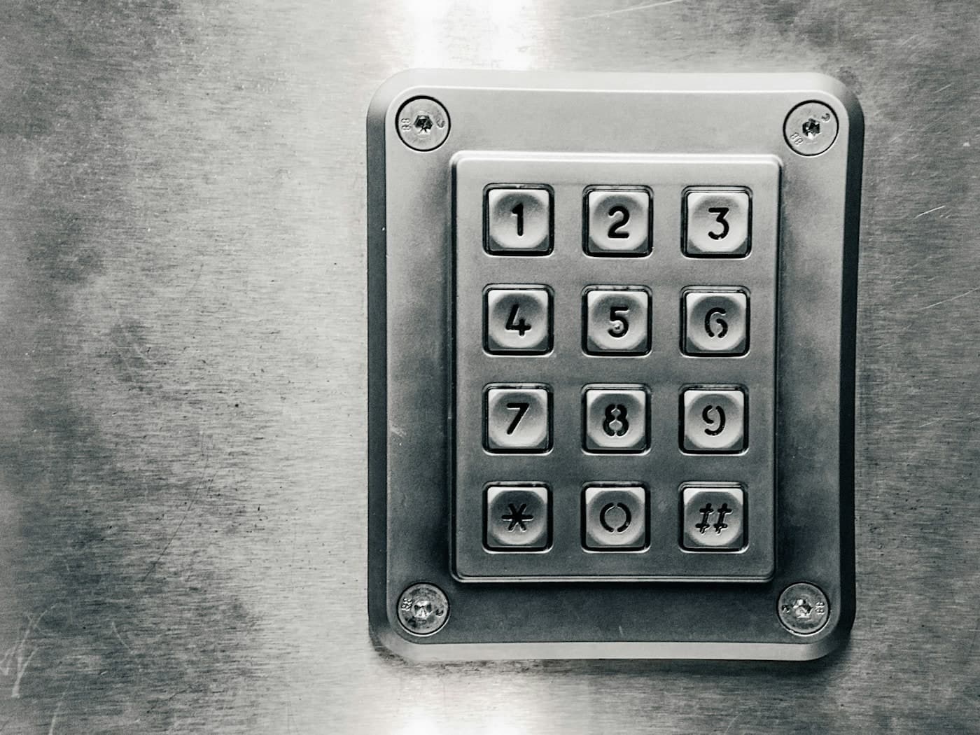 Weatherproof steel keypad fixed to a concrete entry wall