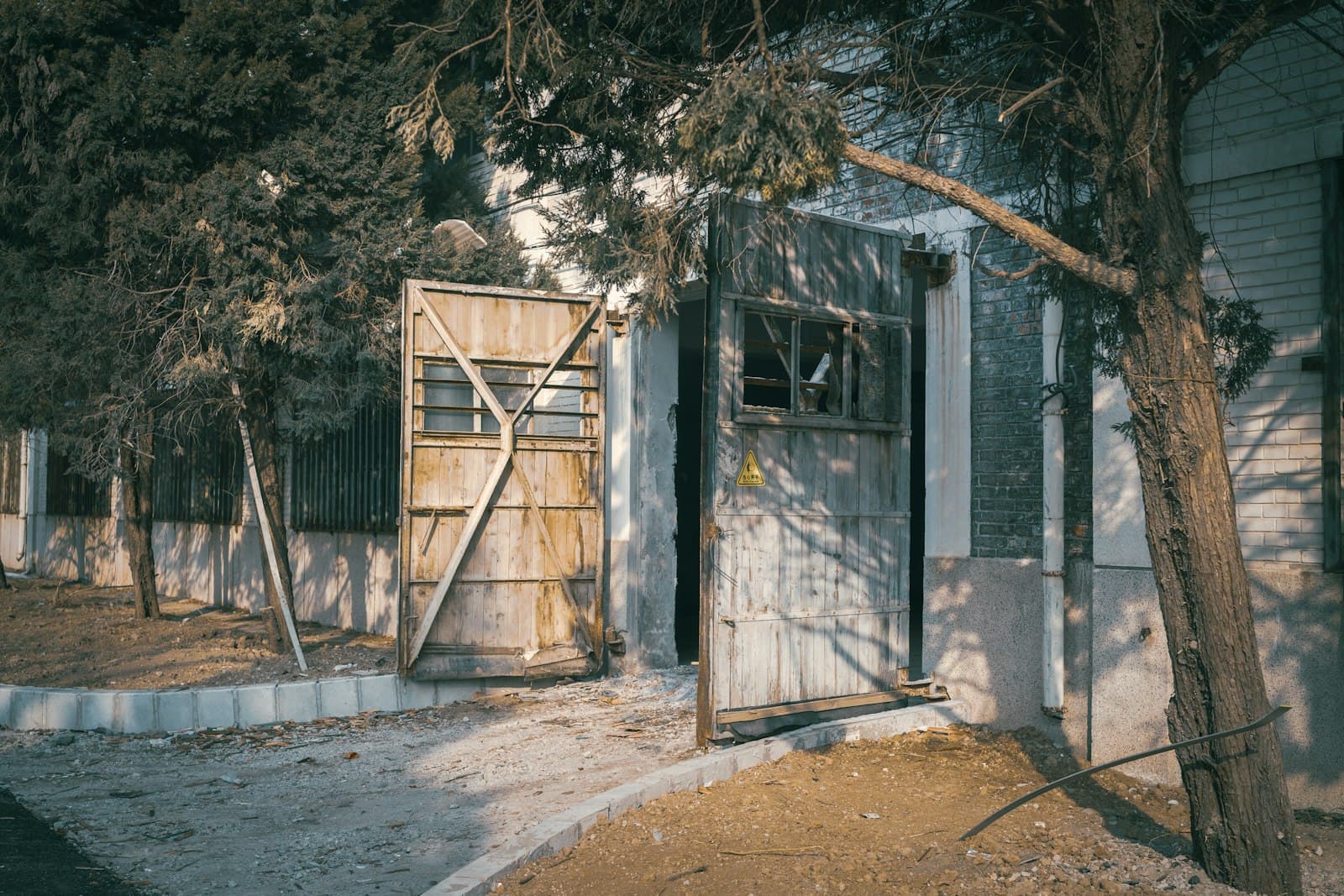 Old iron and timber side gate hanging out of square beside a house