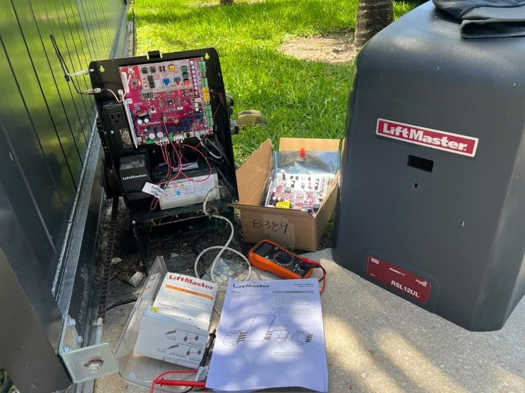 Open gate operator control box with the board out and test gear laid on the ground
