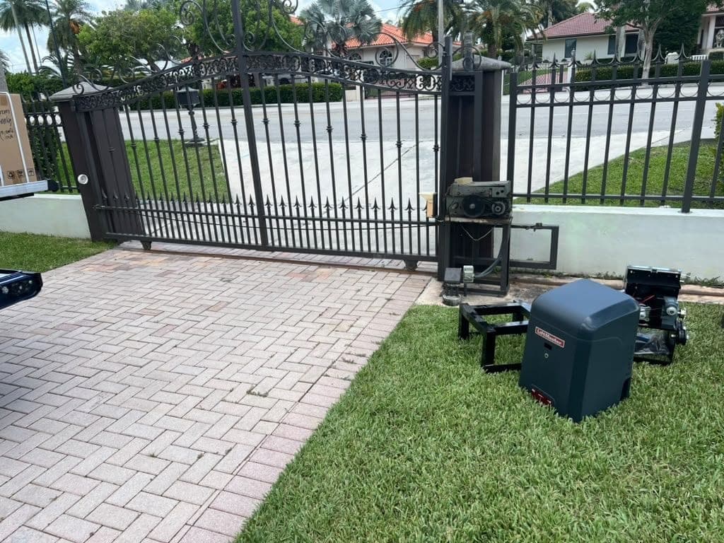 Slide operator installed on its pad beside a black metal fence and driveway